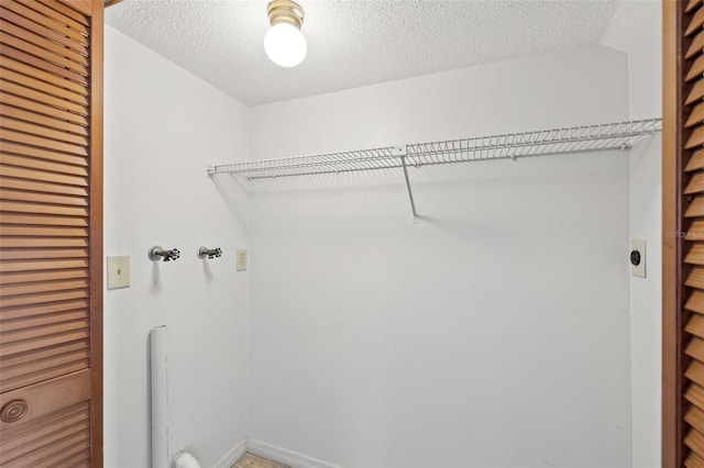 washroom with laundry area and a textured ceiling