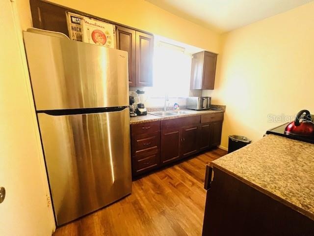 kitchen featuring stainless steel fridge, hardwood / wood-style flooring, and sink