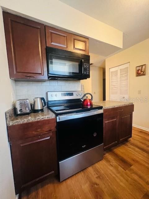 kitchen featuring hardwood / wood-style flooring, tasteful backsplash, stainless steel electric stove, and light stone counters