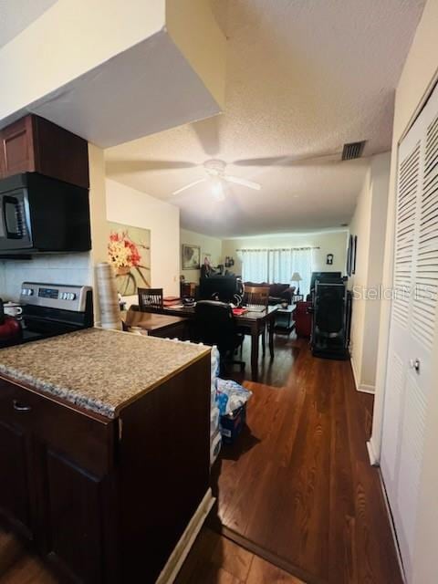 kitchen with electric stove, a textured ceiling, dark brown cabinets, dark hardwood / wood-style flooring, and ceiling fan