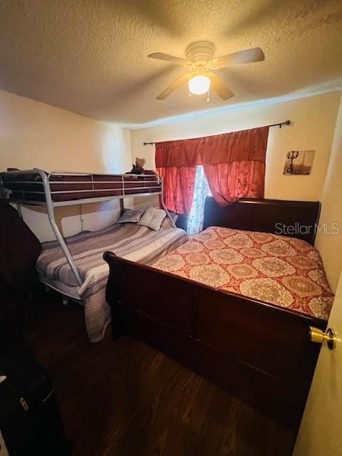 bedroom with a textured ceiling, wood-type flooring, and ceiling fan