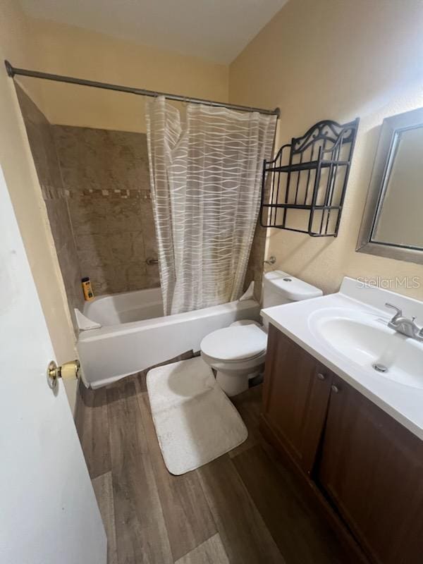 full bathroom with vanity, toilet, hardwood / wood-style floors, and shower / bath combination with curtain