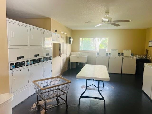 kitchen with ceiling fan, a textured ceiling, white cabinetry, and stacked washer / drying machine