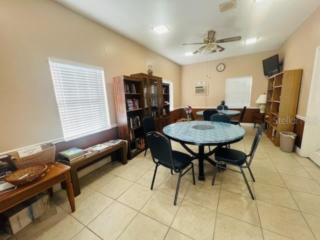 tiled dining area featuring a wall mounted AC and ceiling fan