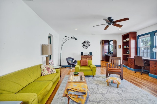 living room featuring light wood-type flooring and ceiling fan