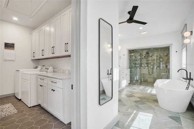 interior space featuring ceiling fan, cabinets, and washing machine and dryer