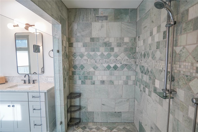 bathroom with a tile shower and vanity