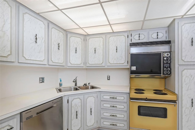 kitchen with white cabinetry, a paneled ceiling, sink, wall oven, and stainless steel dishwasher