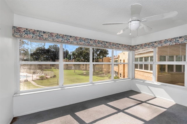 unfurnished sunroom featuring ceiling fan