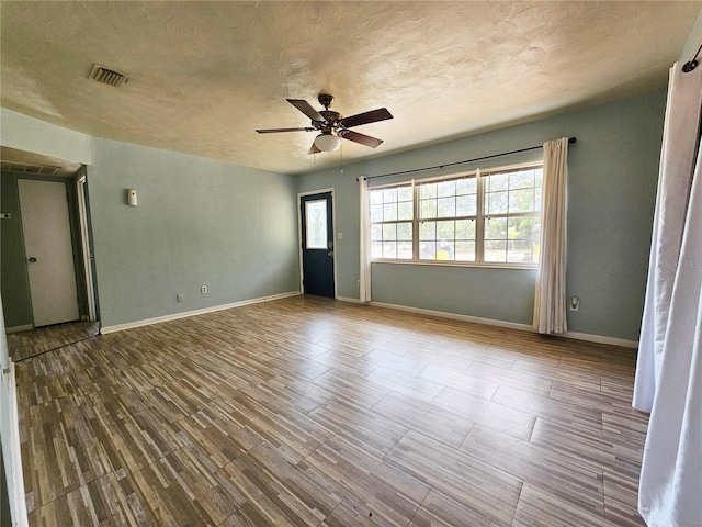 unfurnished room featuring ceiling fan, a textured ceiling, and hardwood / wood-style flooring