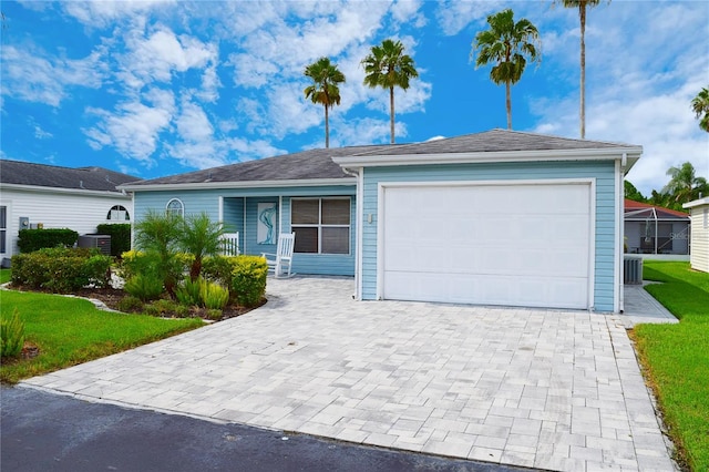 ranch-style house with a garage and central AC unit