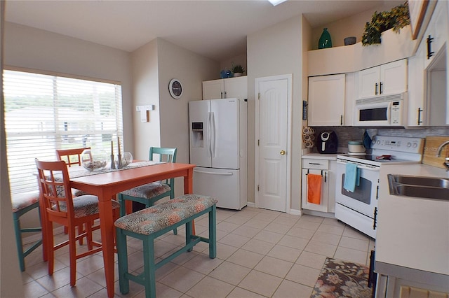 kitchen featuring white cabinets, light tile patterned floors, white appliances, sink, and tasteful backsplash