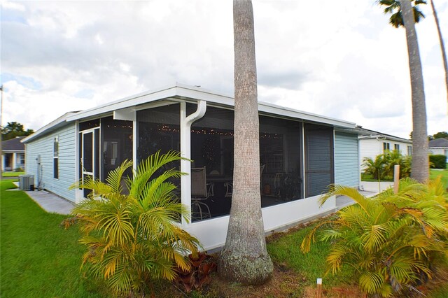 view of property exterior with a sunroom