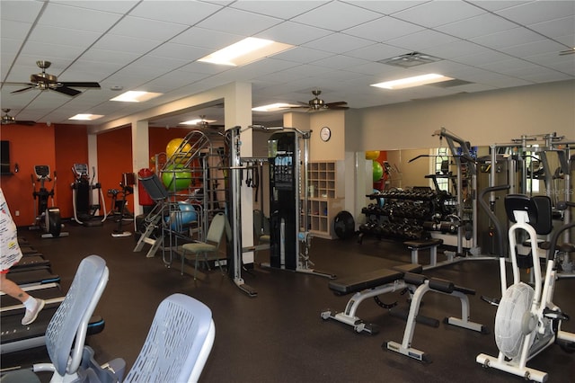 exercise room featuring ceiling fan and a drop ceiling