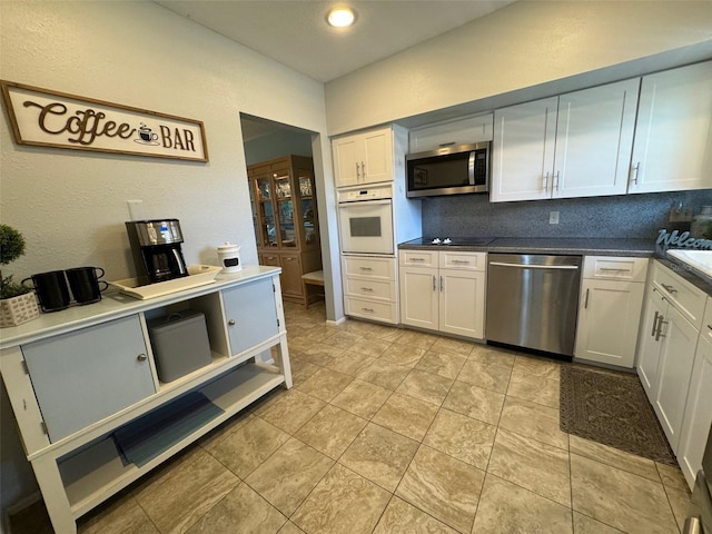 kitchen featuring backsplash, appliances with stainless steel finishes, white cabinets, and light tile patterned flooring