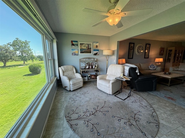 tiled living room with ceiling fan and a textured ceiling