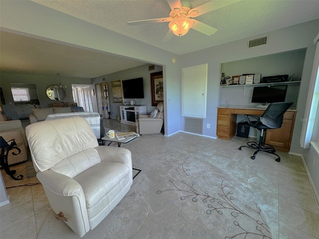 interior space with a textured ceiling and ceiling fan