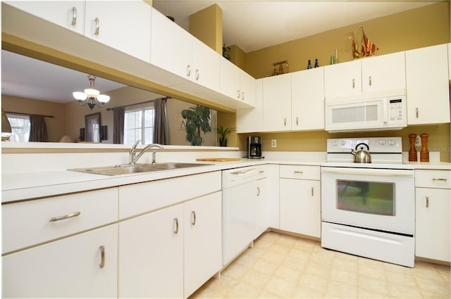 kitchen featuring pendant lighting, a wealth of natural light, white appliances, and white cabinetry