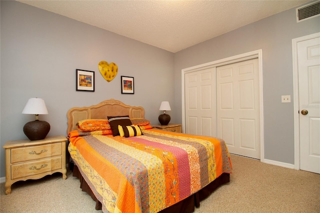 carpeted bedroom with a closet and a textured ceiling