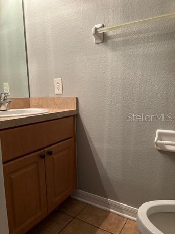 bathroom with vanity, toilet, and tile patterned floors