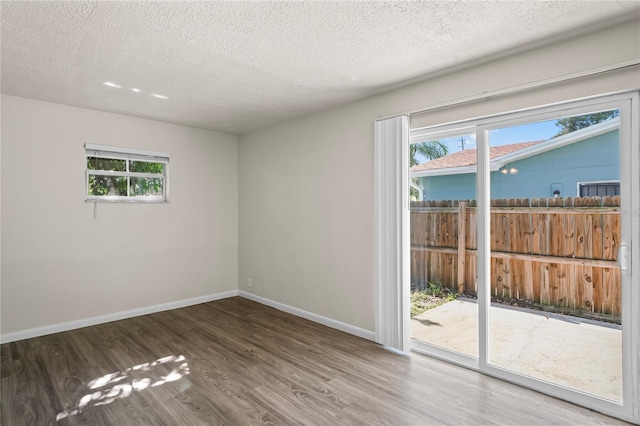 unfurnished room featuring a textured ceiling and hardwood / wood-style floors