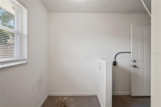 clothes washing area featuring a textured ceiling