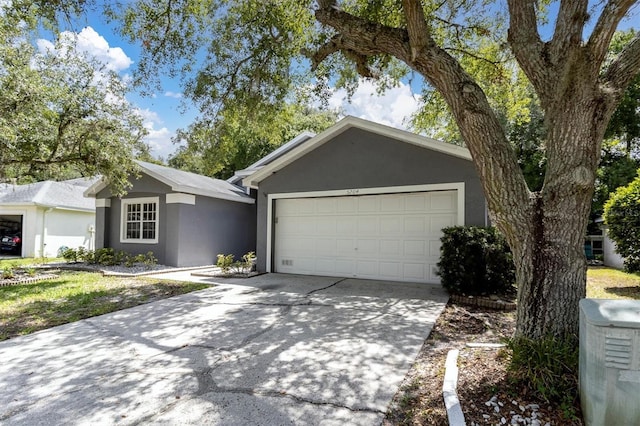 ranch-style house with an attached garage, concrete driveway, and stucco siding