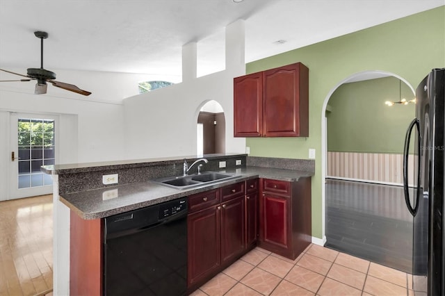 kitchen featuring reddish brown cabinets, dark countertops, a sink, and black appliances