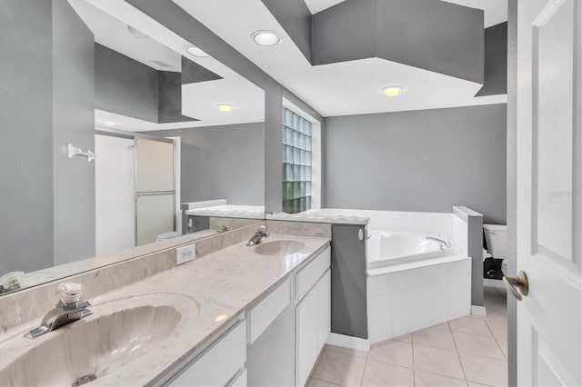 bathroom featuring double vanity, a garden tub, tile patterned flooring, and a sink