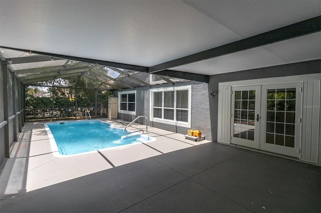 outdoor pool featuring glass enclosure, a patio area, and french doors