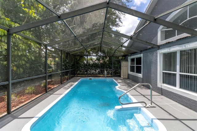 outdoor pool with glass enclosure and a patio area