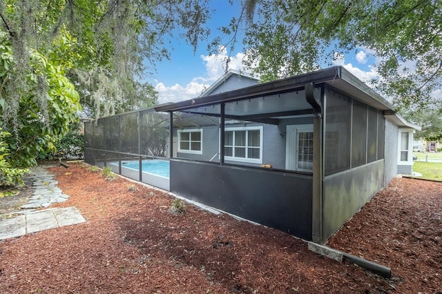 view of property exterior with glass enclosure and an outdoor pool