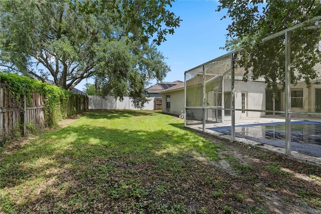 view of yard with a fenced in pool, a patio area, and glass enclosure