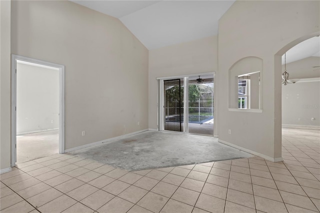 unfurnished room with high vaulted ceiling, ceiling fan, and light tile patterned floors