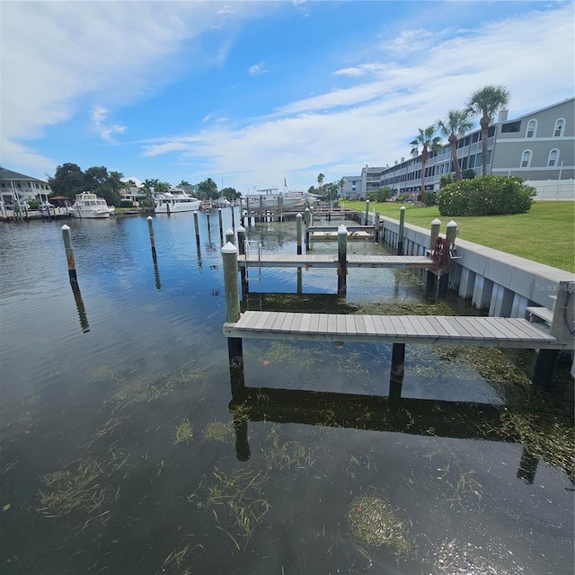 dock area with a lawn and a water view