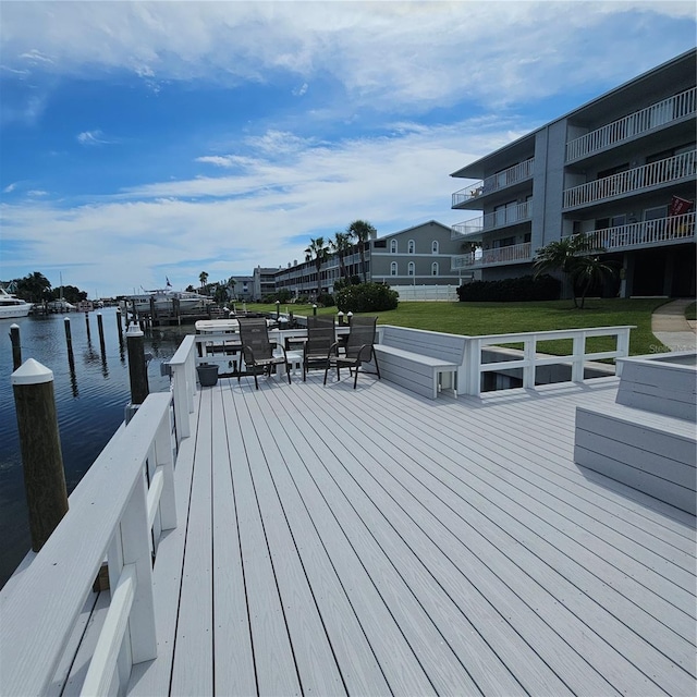 deck with a water view and a yard