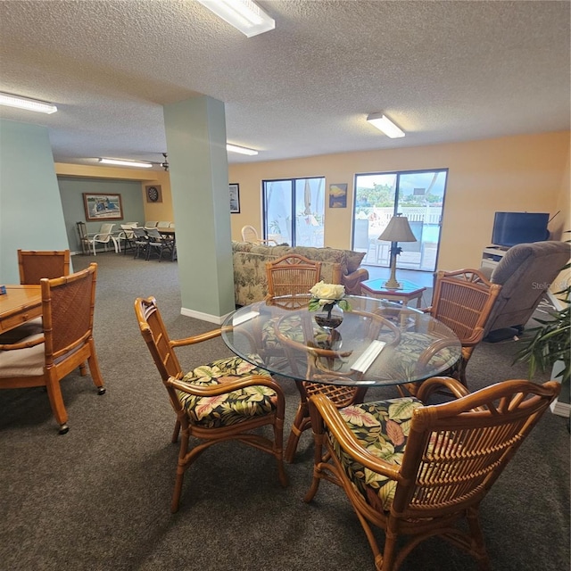 dining area with a textured ceiling and carpet floors