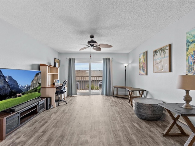 living area with a textured ceiling, ceiling fan, and wood-type flooring