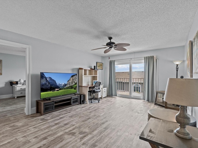 living room featuring a textured ceiling, ceiling fan, and light hardwood / wood-style floors