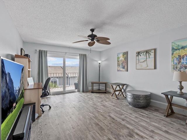 home office featuring a textured ceiling, ceiling fan, and light hardwood / wood-style floors