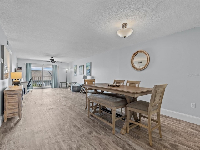 dining area featuring a textured ceiling, hardwood / wood-style floors, and ceiling fan