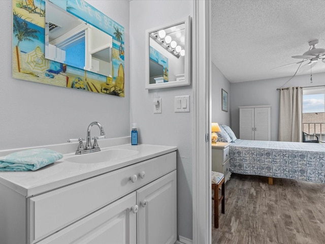 bathroom featuring a textured ceiling, vanity, ceiling fan, and wood-type flooring