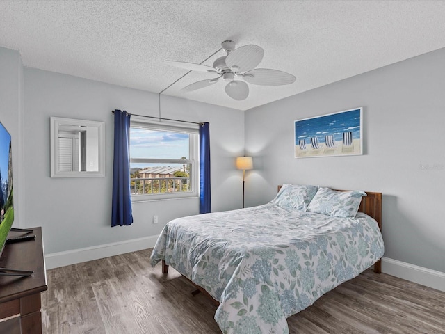 bedroom featuring hardwood / wood-style floors, ceiling fan, and a textured ceiling