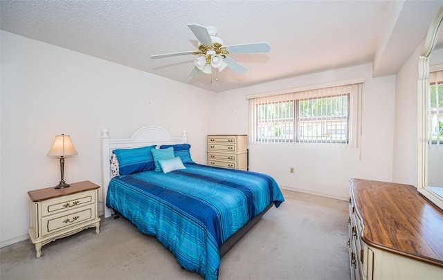 bedroom featuring multiple windows, ceiling fan, and a textured ceiling