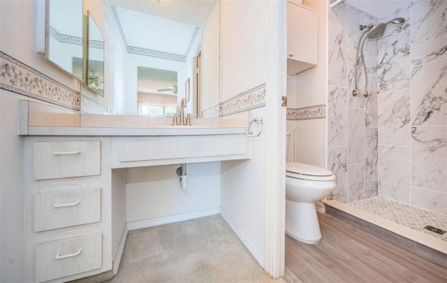 bathroom featuring a tile shower, a textured ceiling, sink, hardwood / wood-style flooring, and toilet