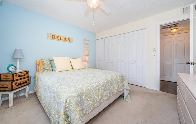 carpeted bedroom featuring ceiling fan, a textured ceiling, and a closet