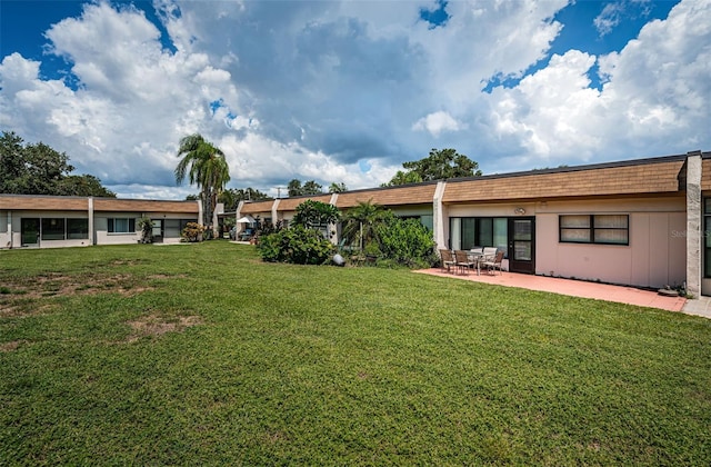 back of house with a yard and a patio area