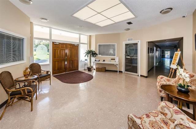 entrance foyer featuring a textured ceiling, visible vents, and baseboards