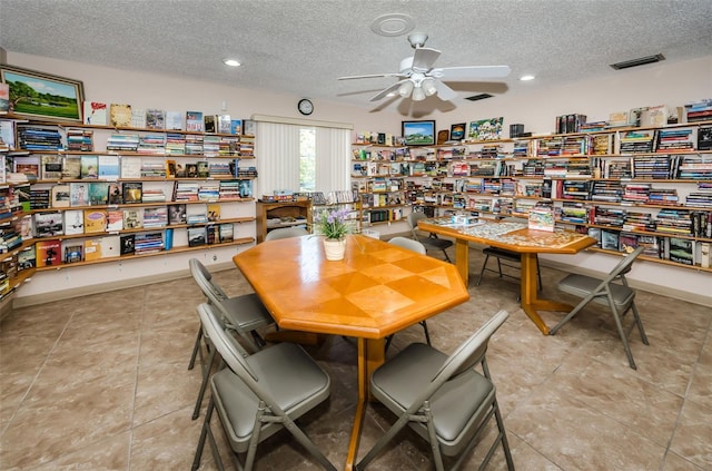 dining room with a textured ceiling, ceiling fan, and light tile patterned flooring