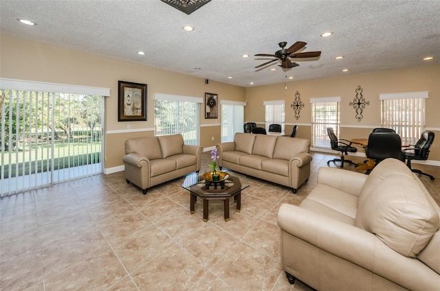 tiled living room with ceiling fan and a textured ceiling